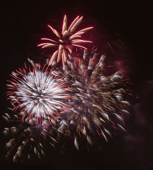 Brightly colorful fireworks and salute of various colors in the night sky background