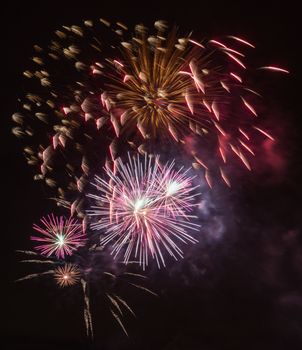 Brightly colorful fireworks and salute of various colors in the night sky background