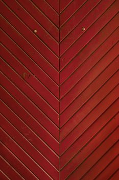 Red vintage grunge stained aged painted wooden panel medieval style door with diagonal planks