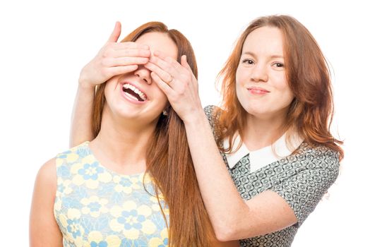 girl covering eyes with hands to her friend portrait on white background