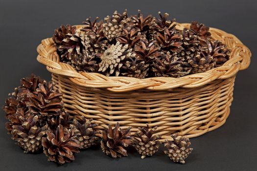 Many pine cones lying in the basket.