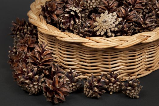 Many pine cones lying in the basket.