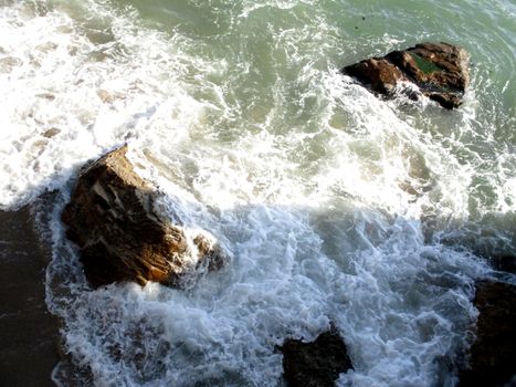 view from above of the waves on the rocks