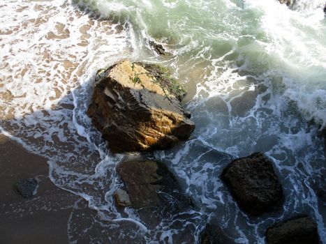 view from above of the waves on the rocks