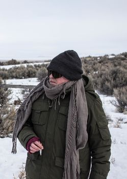 USA, Burns: A man stands in the cold in Burns, Oregon on January 4, 2016, as he and other armed militiamen continue their occupation of a federal building at the Malheur National Wildlife Refuge. Members of the militia say their motives lie in the unfair treatment of Dwight and Steven Hammond, who have been sentenced to five years in prison for burning roughly 130 acres of land in 2001. Prosecutors have accused the Hammonds of burning the land in an attempt to cover up evidence of illegal deer poaching; protesters claim the government has no right to punish the Hammonds for the use of their land.