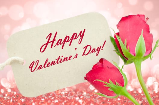 Red roses and happy valentine's card on light background.