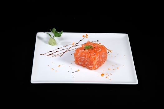 mixed sushi on white plate, black background