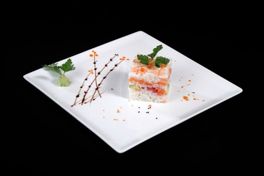mixed sushi on white plate, black background