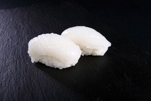 two sushi of flat slate, black background