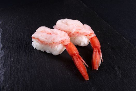 mixed sushi on a black plate, black background