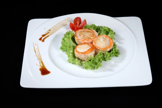 scallop dish with vegetables on a black background