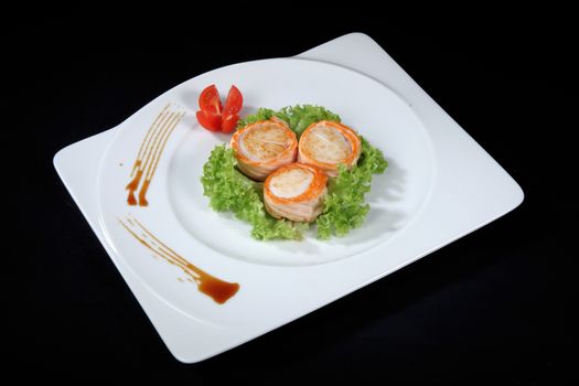 scallop dish with vegetables on a black background