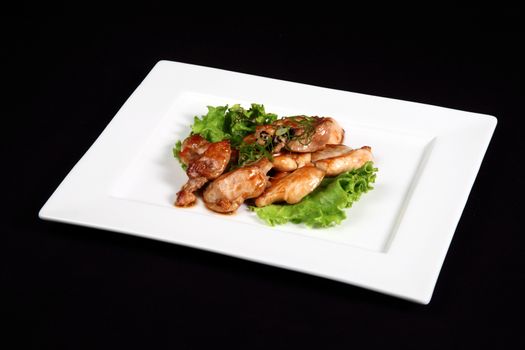 grilled chicken with vegetables in white plate on a black background