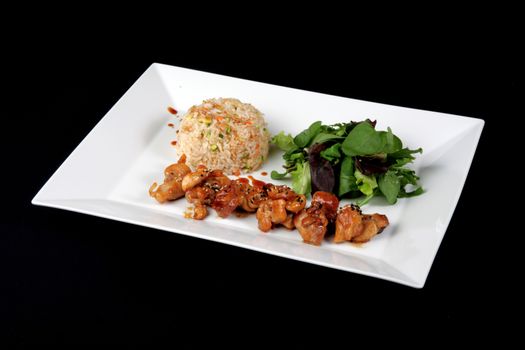 menu of chicken with rice and vegetables on white plate, on black background