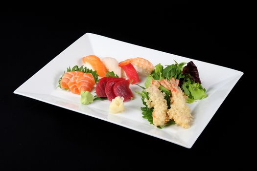 menu of sushi, sashimi and fried with vegetables in white plate on a black background