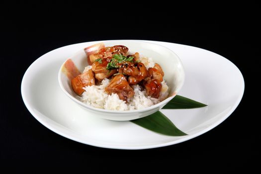 chicken nuggets with rice in white plate on a black background