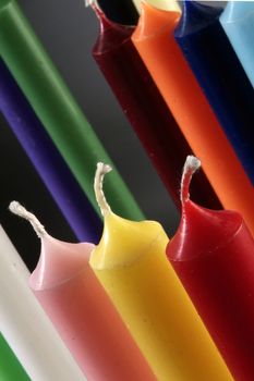 group of colorful cylindrical candles on a black background