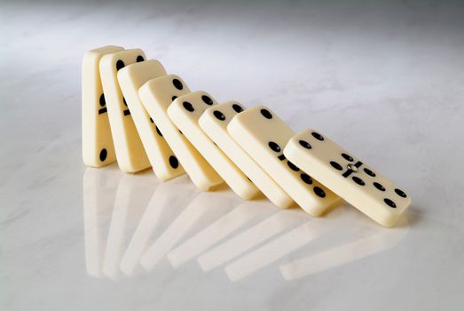 group dominoes fall on a neutral background