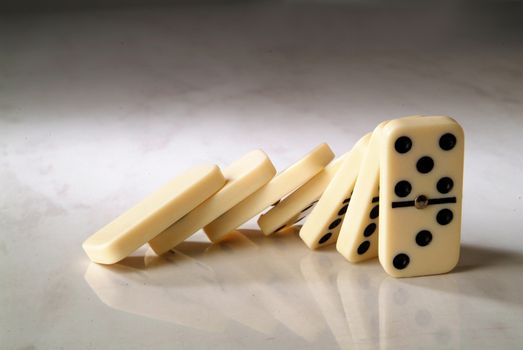 group dominoes fall on a neutral background
