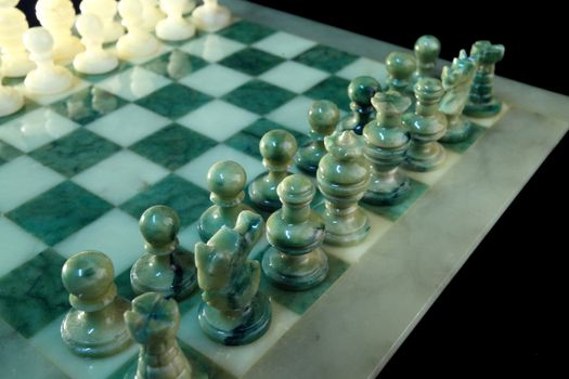 chessboard and alabaster chess on a black background