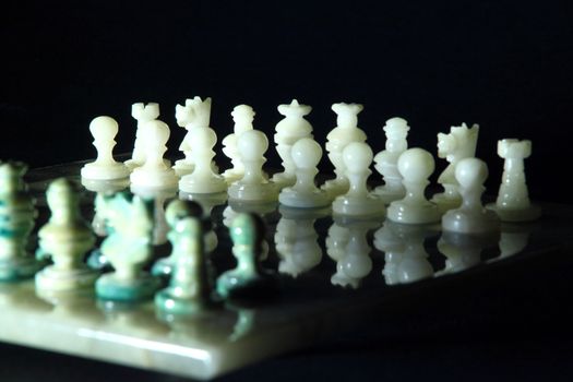 chessboard and alabaster chess on a black background