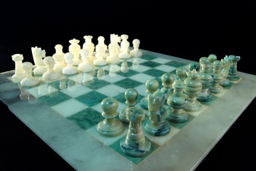 chessboard and alabaster chess on a black background