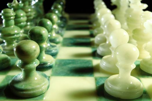 chessboard and alabaster chess on a black background