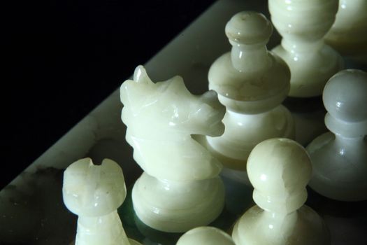 chessboard and alabaster chess on a black background