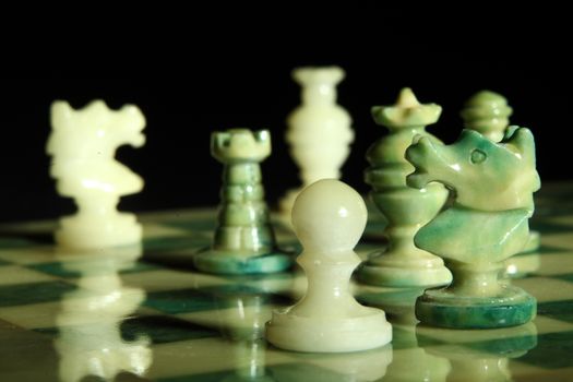 chessboard and alabaster chess on a black background