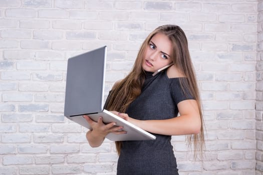 Young beautiful girl model with long hair imitates business lady, office manager or administrator with notebook and telephone