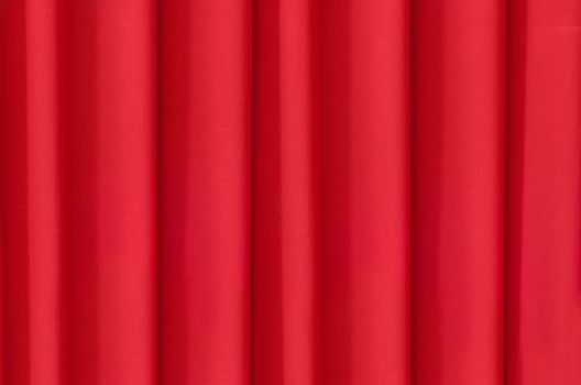 Bright red fabric, draped vertical folds of the curtain.