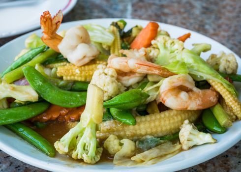 Pad Pak Ruam, stir fried vegetable with shrimps in oyster sauce, the classic Thai vegetable dish. Shallow depth of field with the nearest vegetables in focus.
