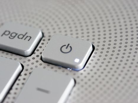 Silver laptop power button close up. Shallow DOF