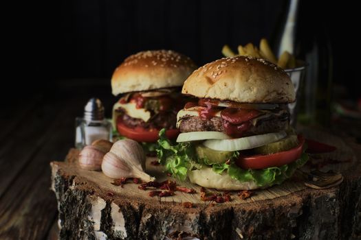 Delicious burgers in a rustic style on dark wooden background.