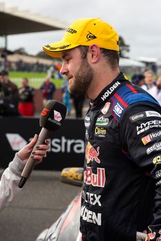 MELBOURNE/AUSTRALIA - SEPTEMBER 17, 2016: Red Bull driver Shane Van Gisbergen being interviewed after his podium finish at the Wilson Security Sandown 500 'Retro' Endurance race at Sandown raceway.