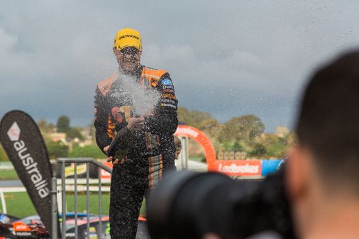 MELBOURNE/AUSTRALIA - SEPTEMBER 17, 2016: Red Bull driver Shane Van Gisbergen spraying champagne after his podium finish at the Wilson Security Sandown 500 'Retro' Endurance race at Sandown raceway.