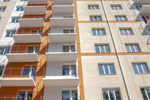 kind of new multistory residential building decorated in orange and yellow colors in sunny day