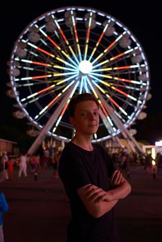 Teen boy in amusement park in night time