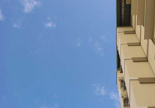 Apartment housing seen from below. Look up building with clear sky background.