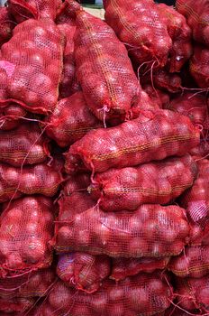 Sacs containing Large onion stacked for sale at Local Market at Little India, Singapore