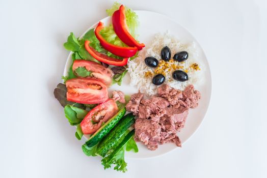 rice tuna chopped vegetables and olives in a white plate on a white background