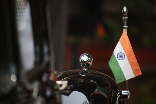 An Indian flag put up on a black vintage car used by the Indian government