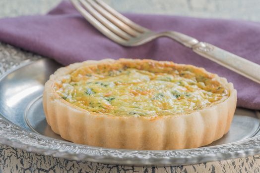 Serving of quiche florentine which is made of eggs, cream, spinach and cheese.