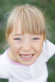 Portrait of the girl in the green bushes, close-up