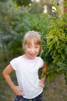 Portrait of the girl in the green bushes, close-up