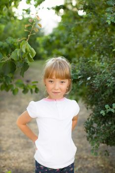 Portrait of the girl in the green bushes, close-up