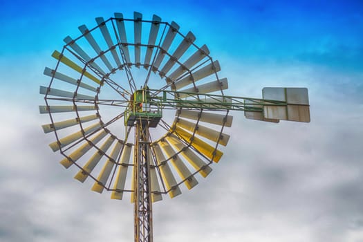 Historic Old Wind Wheell against a blue sky.