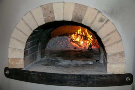 Brick and motar pizza oven with burning fire