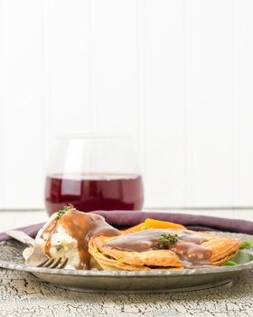 Beef and mushroom meat pie served with mashed potatoes and fresh vegetables.