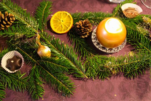 a christmas decorations candles in with fir on a table